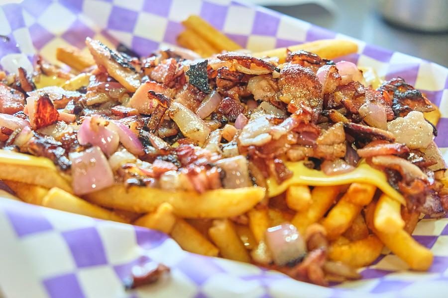 Papas El Bajón con queso, tocino y cebolla asada.